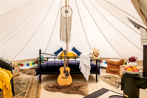 Bell tent interior with king size bed, log burner